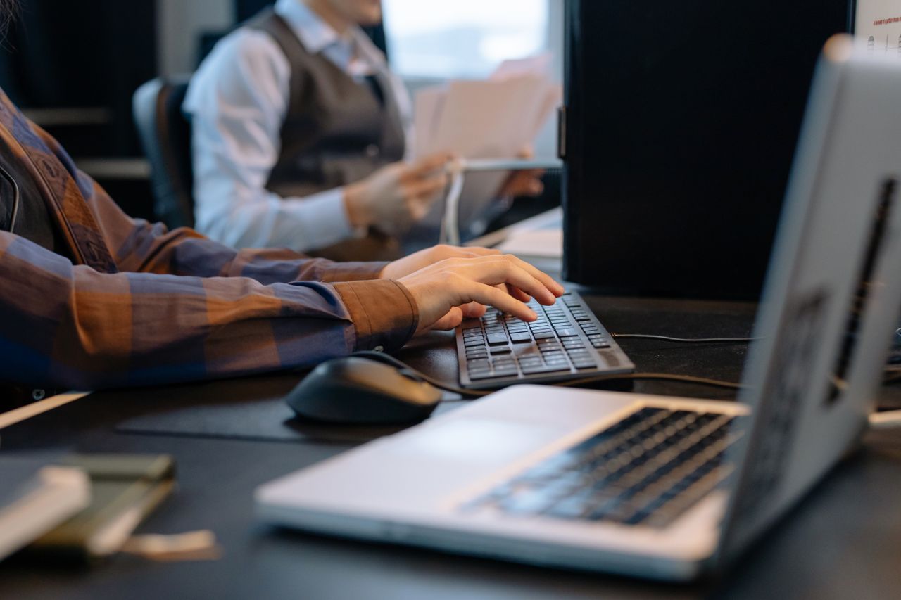 Mastering the First Impression: Your intriguing post title goes here Close-up of office workers engaged in a tech project at a modern workplace.